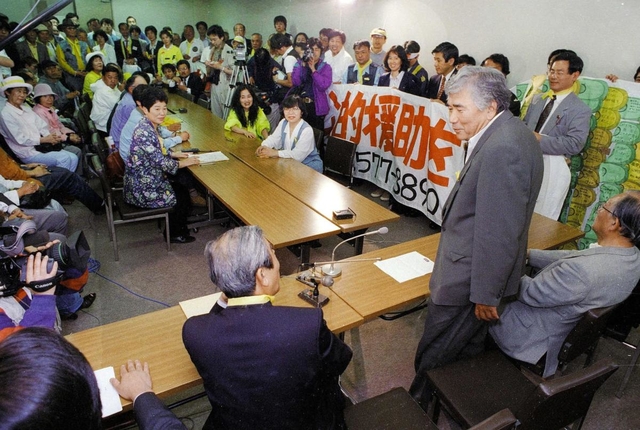法案提出後に参院議員会館の報告集会で話す小田実さん（手前右から２人目）＝１９９７年５月２０日、東京・永田町