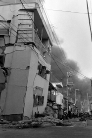 外壁に亀裂が走る建物。黒煙が迫っていた＝１７日午前、神戸市長田区