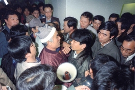 神戸市都市計画審議会の会場入り口付近でもみ合いになる市職員と市民ら＝１９９５年３月１４日