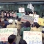 神戸市都市計画審議会が開かれる市役所前でプラカードや横断幕を掲げ、市の復興まちづくり案に抗議する市民ら＝１９９５年３月１４日