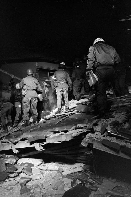 全壊した民家から遺体を収容する警視庁レスキュー隊と自衛隊員＝１８日、西宮市中前田町（撮影・阪神総局員）