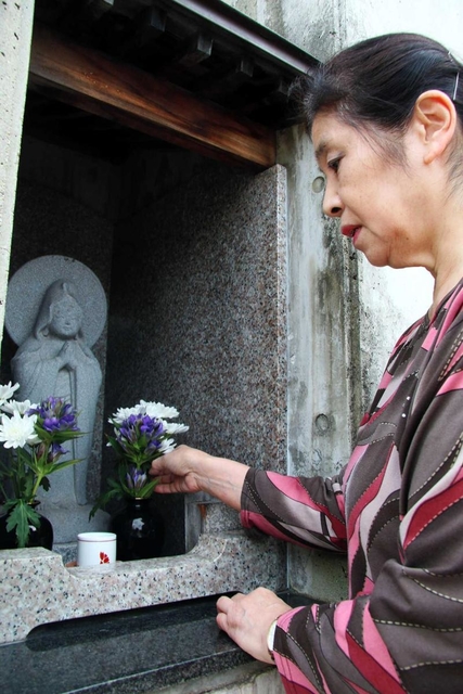 自宅玄関前に設けた「わらべ観音」を見詰める加賀翠さん。像に亡き長女の面影を重ねる＝神戸市東灘区森南町１