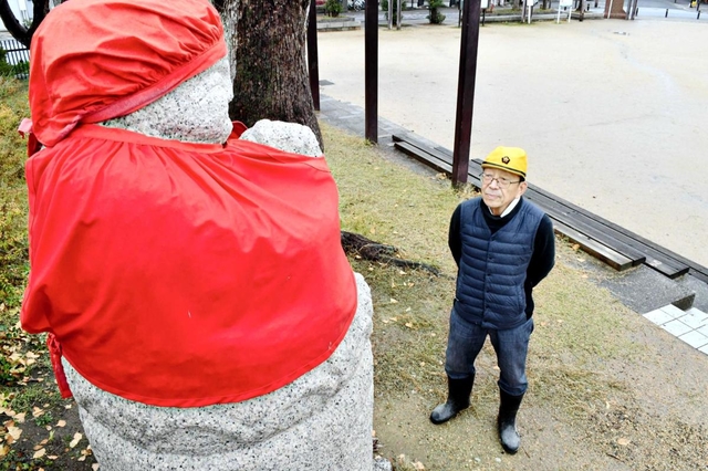 震災犠牲者を追悼して建てられた地蔵を見つめる岩田正幸さん＝神戸市長田区本庄町２