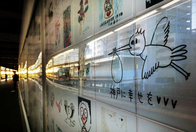 ホームに掲げられた復興を願うイラストとメッセージ＝ＪＲ新長田駅