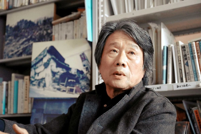 季村敏夫さん。事務所跡に建てたプレハブには震災後に撮った街の写真が置かれている＝神戸市長田区東尻池町１（撮影・斎藤雅志）