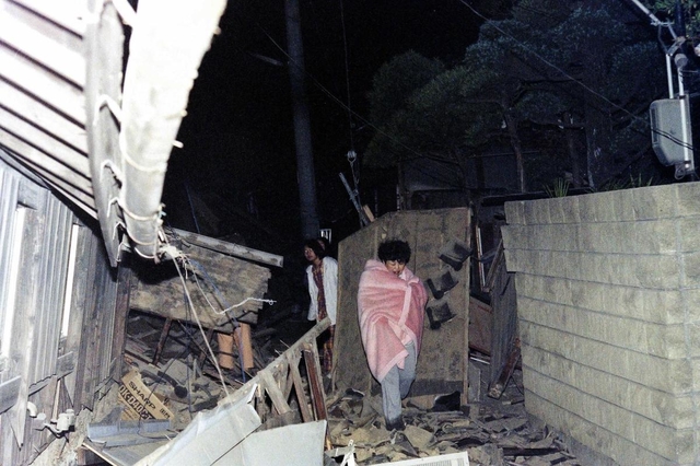 まだ空が白む前、毛布をまとい逃げ出す住民ら。「非日常」が日常となる日々の始まりだった＝１７日早朝、神戸市東灘区