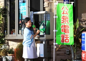 店先には「公衆電話」の大きな文字。受話器を握る岡本美治さん＝神戸市須磨区寺田町１