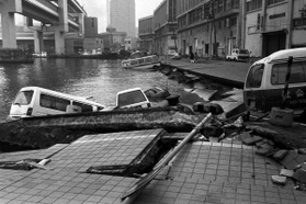 弁天浜では岸壁が崩れ、止めていた車が海中に没した＝１７日、神戸市中央区波止場町