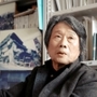 季村敏夫さん。事務所跡に建てたプレハブには震災後に撮った街の写真が置かれている＝神戸市長田区東尻池町１（撮影・斎藤雅志）