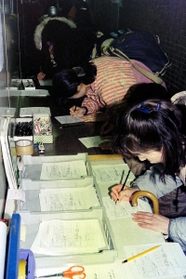 西宮市役所でボランティアの受付窓口で書類を記入する人々＝２２日午後、西宮市六湛寺町
