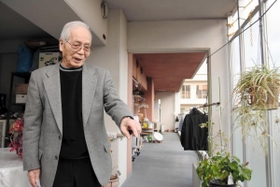 コレクティブハウジングで暮らす岩崎洋三さん。間仕切りのないバルコニーを彩る草花の世話は日課になっている＝神戸市中央区