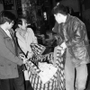 三宮のビル倒壊現場から救出された負傷者を運ぶ人たち＝１９９５年１月１７日午前、神戸市中央区