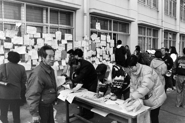 避難所となった学校には、無事や連絡先を知らせるメッセージを記した紙が張られた＝２０日、神戸市長田区