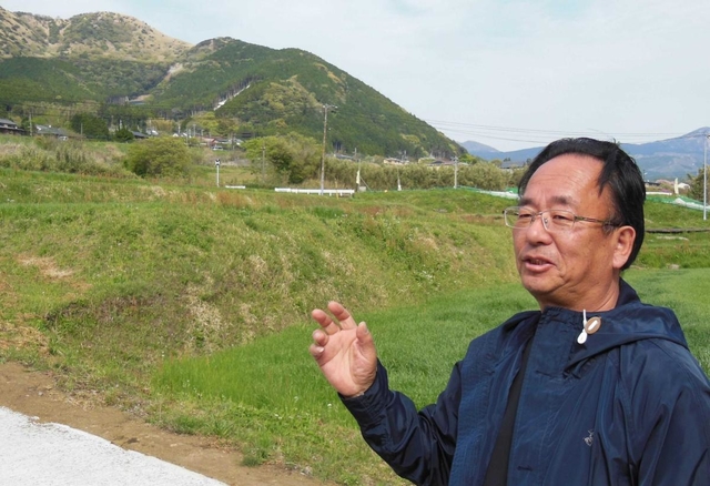 移転先の自宅から、土砂崩れで被災した地区（奥）を望む山内博史さん＝熊本県南阿蘇村立野