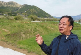 移転先の自宅から、土砂崩れで被災した地区（奥）を望む山内博史さん＝熊本県南阿蘇村立野