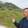 移転先の自宅から、土砂崩れで被災した地区（奥）を望む山内博史さん＝熊本県南阿蘇村立野