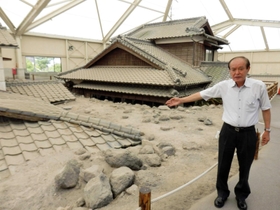 「土石流被災家屋保存公園」の遺構を指す川田喜伝治さん＝長崎県南島原市深江町