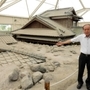 「土石流被災家屋保存公園」の遺構を指す川田喜伝治さん＝長崎県南島原市深江町
