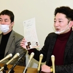 １・１７の集いに並べる紙灯籠について説明する藤本真一さん（右）＝１４日午後、神戸市役所