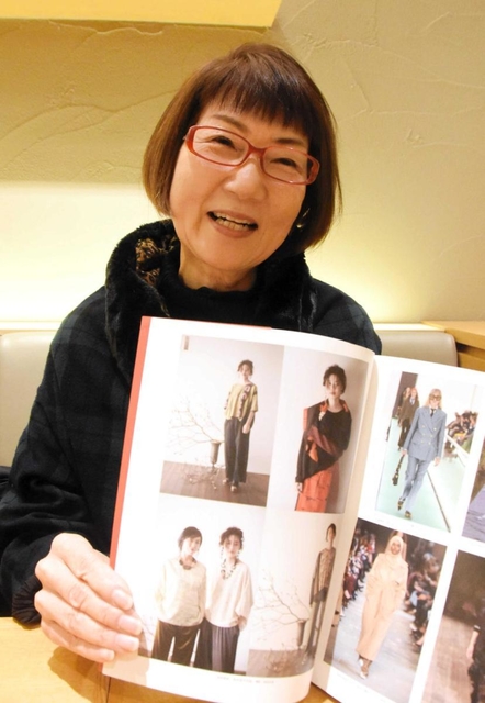 ユニバーサルファッションを紹介する自著を手にする見寺貞子さん＝神戸市中央区小野柄通
