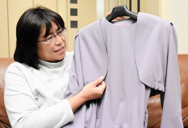 有明結香さんが着ていたドレスを見つめる高松寿賀子さん＝加古川市