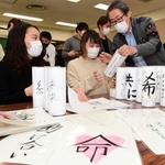 紙灯籠を製作する若者たち。震災のボランティアに携わった堀内正美さん（右）も作業に加わった＝神戸市長田区若松町５（撮影・中西幸大）