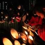 竹灯籠に火をともす人たち＝１７日午前４時４８分、神戸市中央区加納町６（撮影・大森　武）