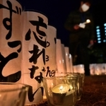 初めて設けられた紙灯籠。「ずっと」「忘れない」の言葉がろうそくの柔らかな明かりで浮かび上がった＝１７日午前６時２８分、神戸市中央区加納町６、東遊園地（撮影・秋山亮太）