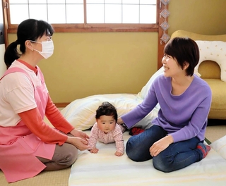 預かっていた赤ちゃんを授乳のため個室に連れて行き、利用する母親と談笑するイルマズさん（左）＝神戸市須磨区大黒町３、助産所ポスチャー