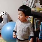 豆を両手に握りしめドアのほうを見つめる次男