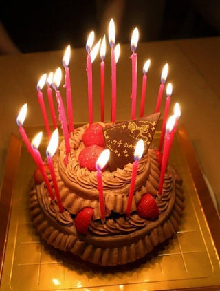ろうそくを20本立てて燃え上がりそうな誕生日ケーキ