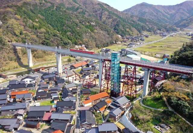 集落をまたぐように架けられた橋りょう。長い歴史を刻み、地域の景観に溶け込む（小型無人機より撮影）＝兵庫県香美町香住区余部