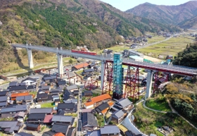 集落をまたぐように架けられた橋りょう。長い歴史を刻み、地域の景観に溶け込む（小型無人機より撮影）＝兵庫県香美町香住区余部