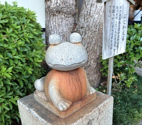 【４】ぶじかえる　「びっくりしたい人は目玉を、借金で困っている人は首を回してください」と案内のあるカエルの置物。あっちこっちを見渡して、お寺を見守っているのかな？