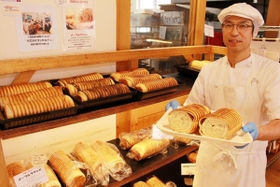 １８年続く名物「ラウンドパン」を手にする橋本英治さん＝神戸市須磨区多井畑南町