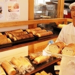 １８年続く名物「ラウンドパン」を手にする橋本英治さん＝神戸市須磨区多井畑南町