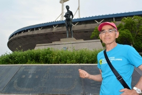 「勝利者の像」の前で思い出を語る男性（７３）＝神戸総合運動公園
