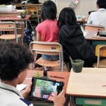 タブレットで植物観察の写真を撮影する児童＝若草小学校