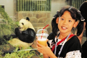 王子動物園名物「パンダと一緒・ミックスジュース」パンダのエサ、笹、リンゴ、ニンジンを素材にしたジュースを手に写真に収まる女の子＝２００４年９月、神戸市灘区、市立王子動物園