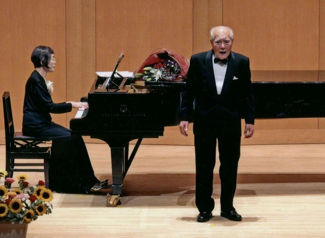 「９０歳の挑戦　歌曲コンサート」で歌う陰山恭道さん（右）と伴奏する陽子さん（陰山恭道さん提供）