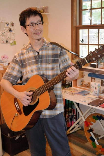 「ギターを持っていないと安心できない」というオーナーの平山慎二さん＝神戸市垂水区舞子台８