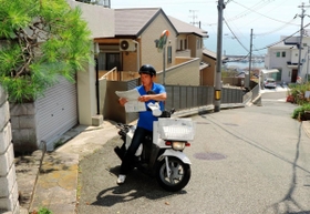 塩屋地区のきつい坂でも二輪車を駆使して配達する水谷義孝所長＝神戸市垂水区塩屋町５