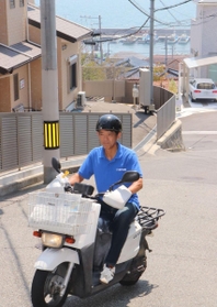 塩屋地区のきつい坂でも二輪車を駆使して配達する水谷義孝所長＝神戸市垂水区塩屋町５