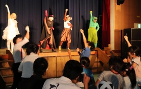 掛け声に合わせ、出演者と腕を高く突き上げる子どもら＝県立神戸聴覚特別支援学校