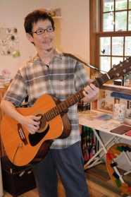 「ギターを持っていないと安心できない」というオーナーの平山慎二さん＝神戸市垂水区舞子台８