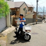 塩屋地区のきつい坂でも二輪車を駆使して配達する水谷義孝所長＝神戸市垂水区塩屋町５