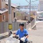 塩屋地区のきつい坂でも二輪車を駆使して配達する水谷義孝所長＝神戸市垂水区塩屋町５