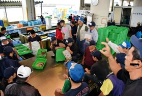 鮮魚商が指を立てて値段をつけ、次々と競り落としていく昼網の様子＝垂水漁港