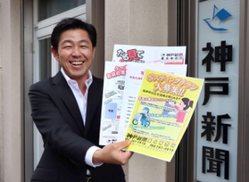 ポスティング募集やクーポン付きのチラシを掲げる左座所長＝垂水区宮本町