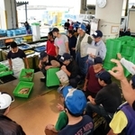 鮮魚商が指を立てて値段をつけ、次々と競り落としていく昼網の様子＝垂水漁港